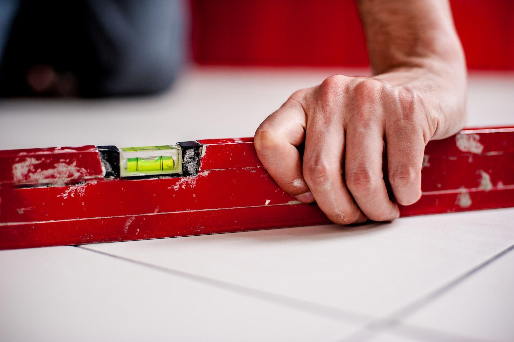 Close up of hand on leveler on uneven floor