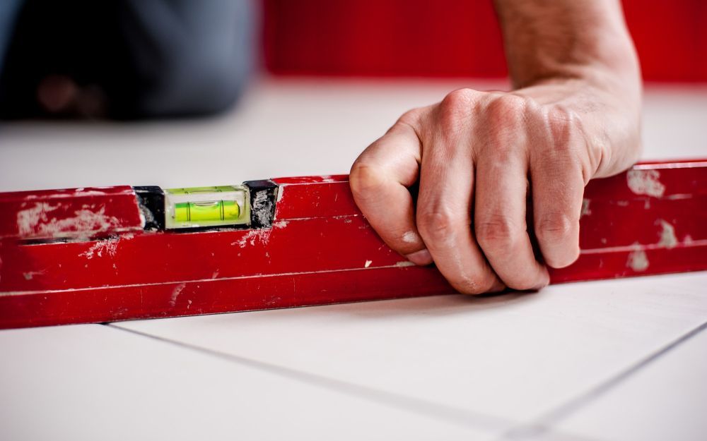 Close up of hand on leveler on uneven floor