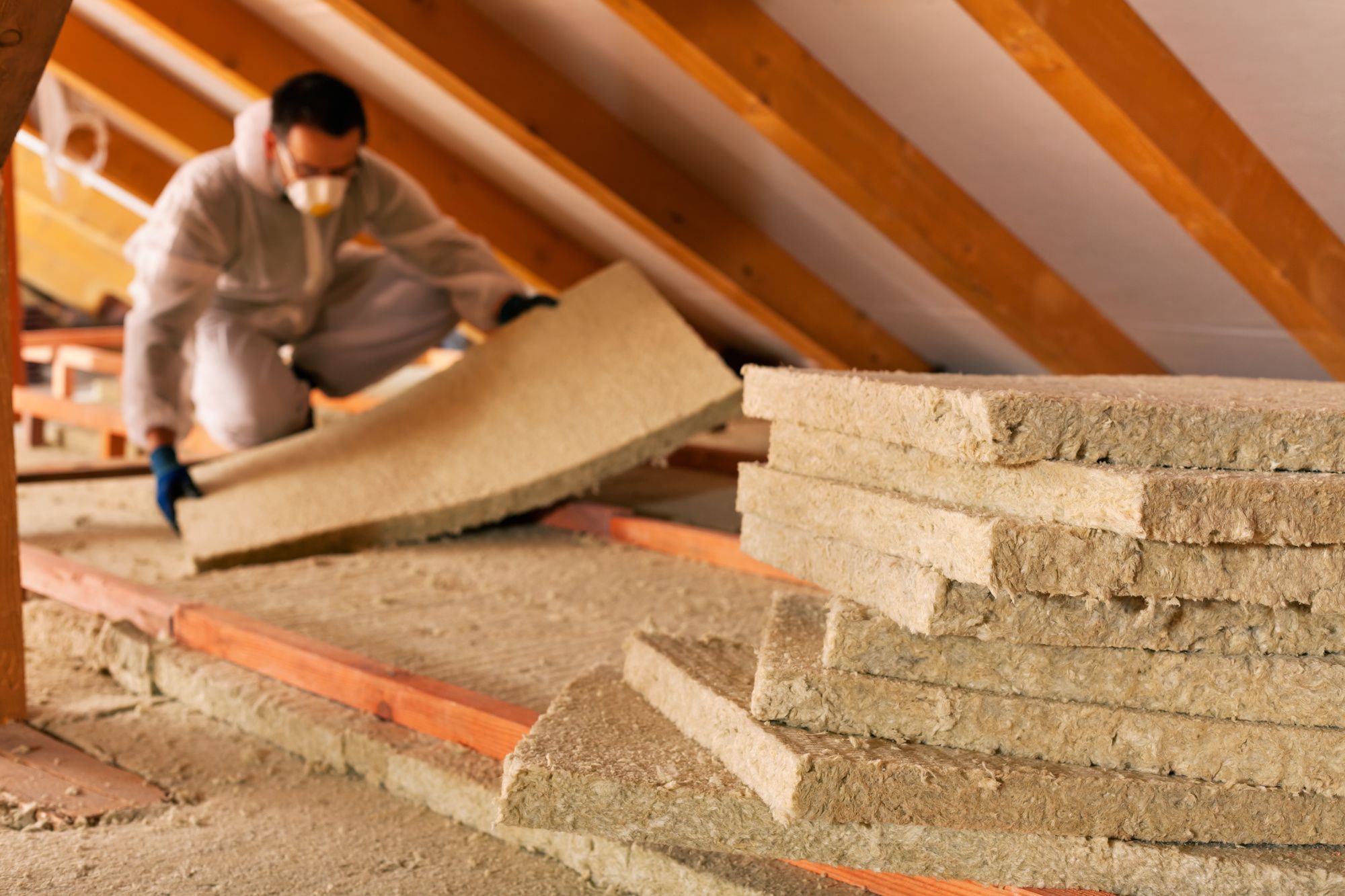 Man laying Insulation in attic